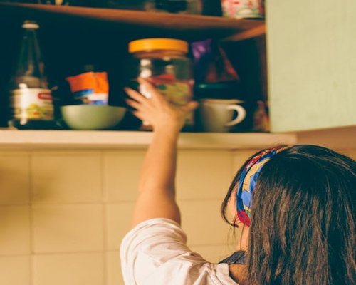 Someone organizing items on shelves at home