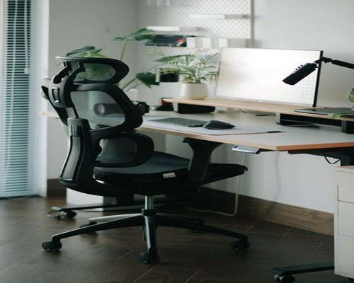 Person adjusting their ergonomic chair in a home office